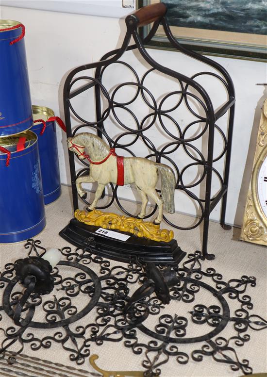 A pair of decorative wrought iron sconces, a wine rack and a horse door stop